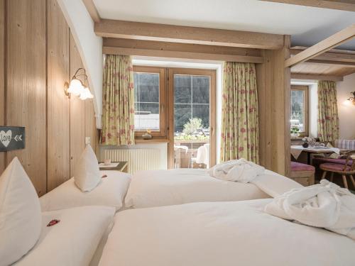 a hotel room with three beds and a window at Apparthotel "Landhaus Veronika" in Mayrhofen