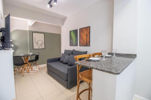 eine Küche und ein Wohnzimmer mit einer Couch und einem Tisch in der Unterkunft JOA22 - 1 Suíte, TV Smart, Aconchegante, Garagem in Balneário Camboriú