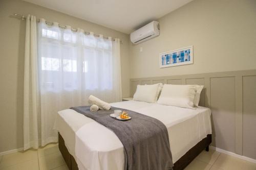ein Schlafzimmer mit einem Bett mit einem Teller Essen drauf in der Unterkunft JOA22 - 1 Suíte, TV Smart, Aconchegante, Garagem in Balneário Camboriú