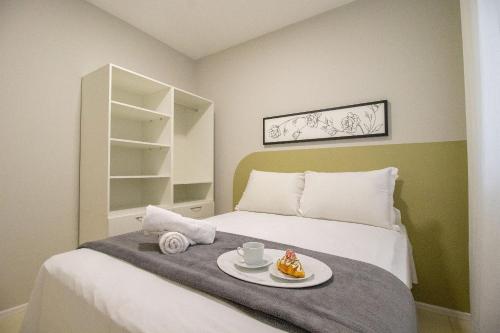 Un dormitorio con una cama con una bandeja de comida encima. en JOA23 - 1 Dorm, Climatizado, Garagem, TV Smart, en Balneário Camboriú