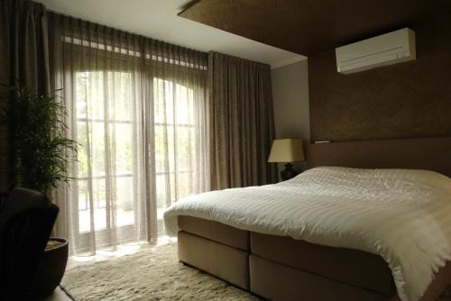 a bedroom with a bed and a large window at Huisje Bommelstein in Joure