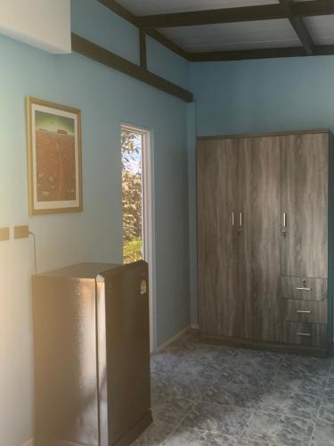 an empty room with a refrigerator and a cabinet at Pajaree and Udo‘s Happy Homestay in Trang