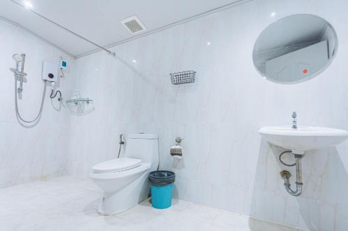 a white bathroom with a toilet and a sink at X Mitr Inn Nimman มิตร อินน์ นิมมาน 12 in Chiang Mai