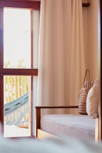 a bedroom with a bed and a window at Villa Estrela Bungalow in Itacaré