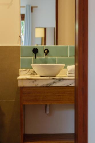 a bathroom sink with a bowl on top of it at Villa Estrela Bungalow in Itacaré