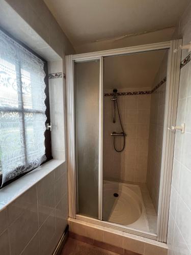 a shower with a glass door in a bathroom at Le Refuge de la Liberté in Montmartin-en-Graignes