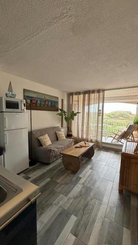 un salon avec un canapé et une table dans l'établissement Belle vue mer, plage 90 m, parking, loggia, wifi., au Cap d'Agde