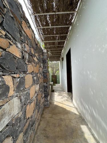 a building with a stone wall and a ceiling at Casa com pátio e pequena piscina in Ribeira Fria