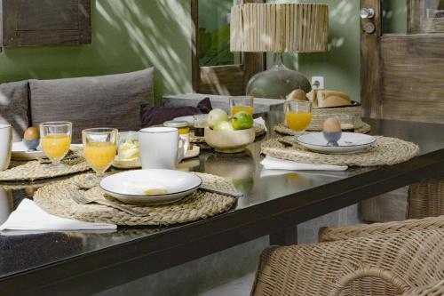 a dining table with plates and glasses of orange juice at Casa com pátio e pequena piscina in Ribeira Fria