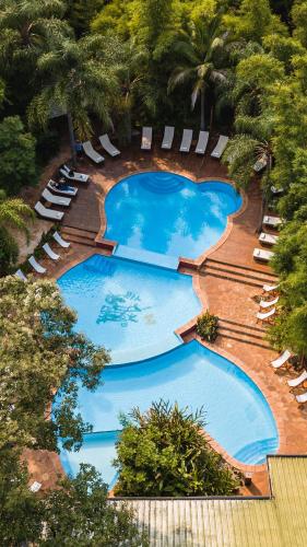 an overhead view of a large swimming pool with lounge chairs at La Aldea De La Selva Lodge in Puerto Iguazú
