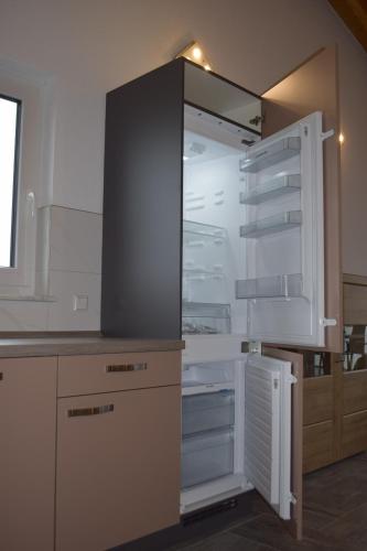 un frigorifero vuoto con la porta aperta in una cucina di Ferienhaus 2 - 55471 Reich - EG - OG a Reich