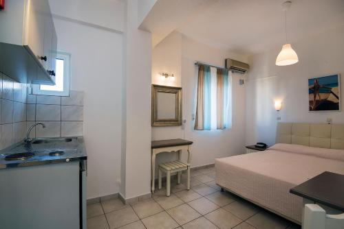 a small room with a bed and a sink in it at Diamond Apartments & Suites in Hersonissos