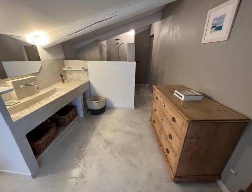 a bathroom with a sink and a vanity with a wooden table at Le Mas Lolivo in Aubignan