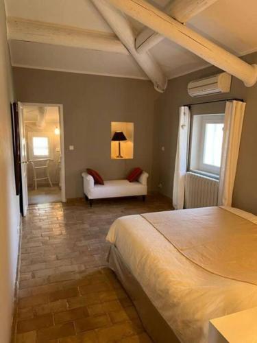 a bedroom with a bed and a couch in a room at Le Mas Lolivo in Aubignan
