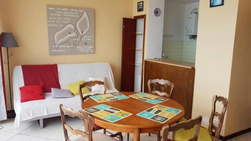 une table et des chaises dans une cuisine avec une table et un canapé dans l'établissement Front de mer pour ce charmant T2 proche commerces - 6OND33, à Saint Cyprien Plage