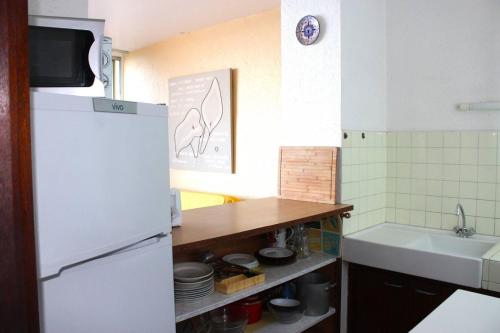une cuisine avec un réfrigérateur blanc et un évier dans l'établissement Front de mer pour ce charmant T2 proche commerces - 6OND33, à Saint Cyprien Plage