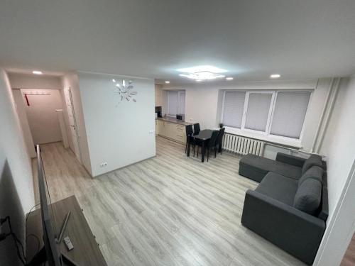 an empty living room with a couch and a kitchen at Butas miesto centre in Panevėžys