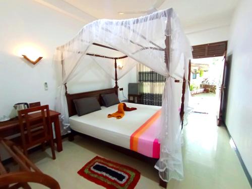 a bedroom with a bed with a teddy bear on it at Ramesh Guesthouse in Mirissa