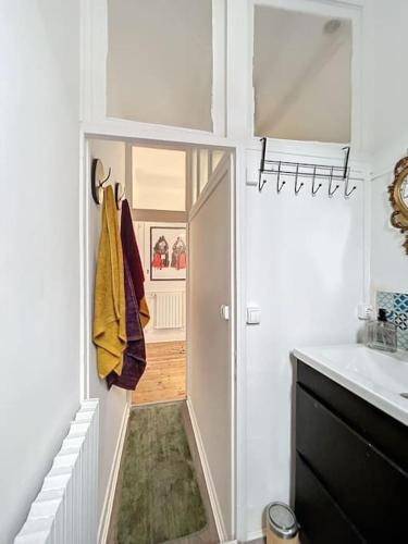 une salle de bain avec une porte donnant sur un couloir dans l'établissement Le clos des bulles, à Épernay