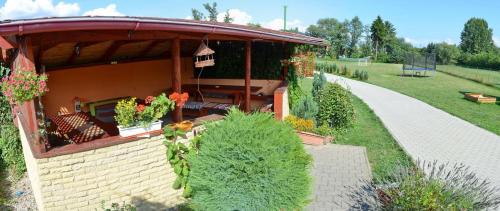a garden with a small building with a porch at Penzion Mirabel in Bešeňová