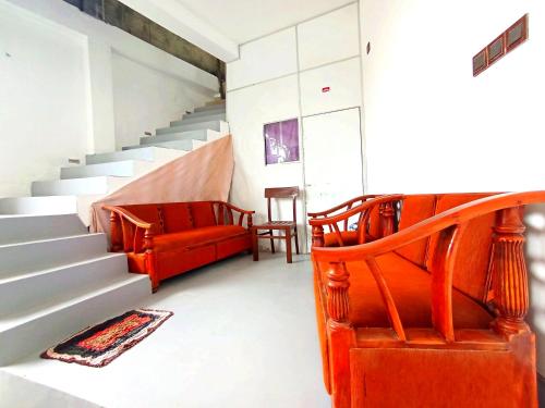 a living room with a red couch and stairs at Ramesh Guesthouse in Mirissa