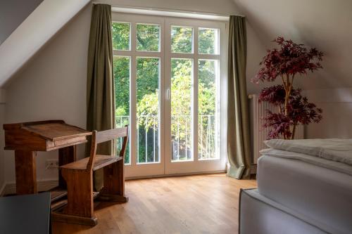 a bedroom with a large window and a bed and a desk at Altstadt Apartments Verden in Verden