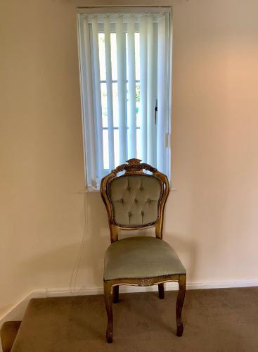a chair sitting in front of a window at Lorton Villa with a Log Burner in Saint Helens