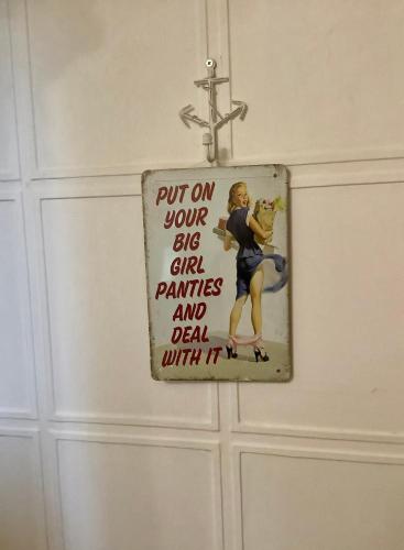 a sign on a door that says put on your sins girl paintings and dead with at Lorton Villa with a Log Burner in Saint Helens