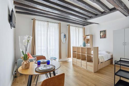 un salon avec une table et un lit dans l'établissement Charming Studio Center of Paris, à Paris