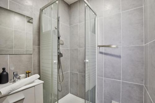 une douche avec une porte vitrée dans une salle de bain dans l'établissement Charming Studio Center of Paris, à Paris