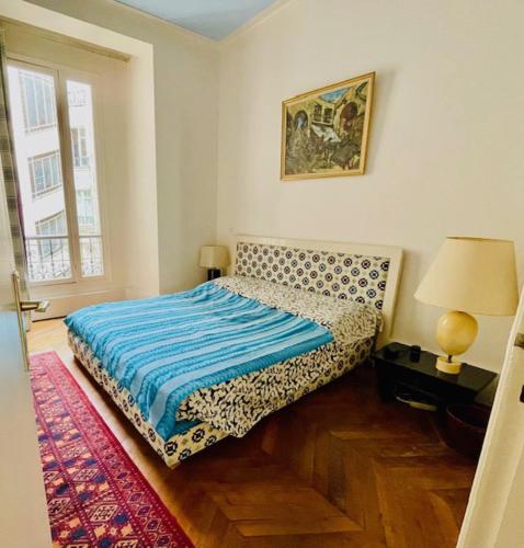 une chambre avec un lit avec une couverture bleue dans l'établissement appartement pres de la tour eiffel, à Paris