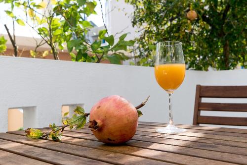 an apple and a glass of orange juice on a wooden table at Diamond Apartments & Suites in Hersonissos