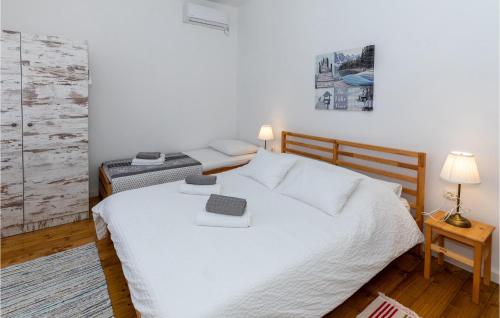 a bedroom with a large white bed and a table at 4 Bedroom Beautiful Home In Rogotin in Rogotin