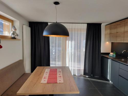 a kitchen with a wooden table and a black light at Ciüf de Munt in Badia