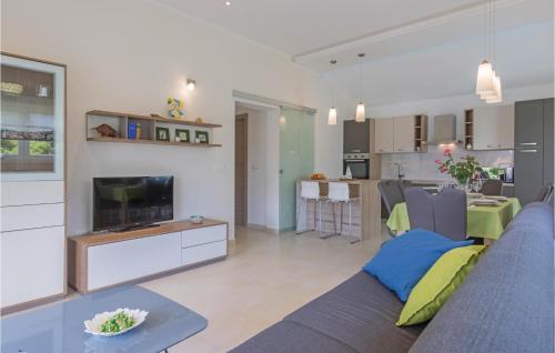 a living room with a blue couch and a television at Two-Bedroom Holiday Home In Vodnjan in Vodnjan