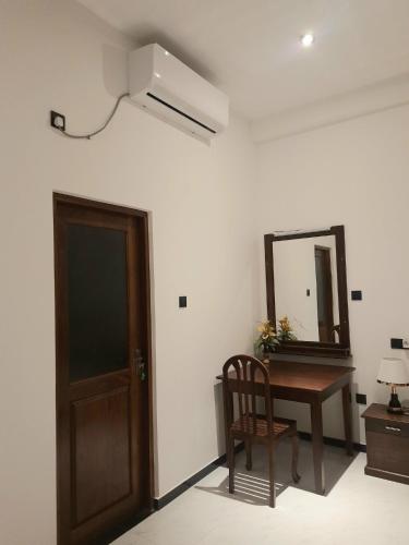 a room with a table and a mirror and a chair at Coco Mount Residence - Hiriketiya in Dickwella