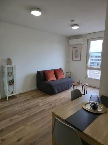 un salon avec un canapé et une table dans l'établissement 302 - 2 pièces tout équipé à Strasbourg, à Strasbourg