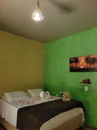 a green bedroom with a bed with a stuffed animal on it at Vila Coqueiro - Moitas in Amontada