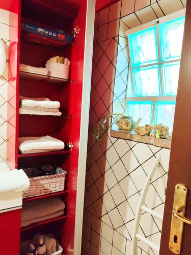 a bathroom with a red cabinet with towels at "La casetta" indipendente, con ampio spazio verde in Fontechiari