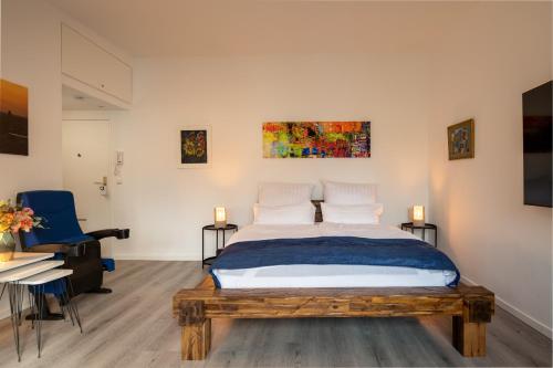 a bedroom with a bed and a blue chair at Boardinghouse Hohenzollern in Berlin