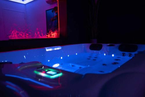 a bathroom with a bathtub with a green light in it at LA NUIT DES SECRETS Love Room 4 étoiles avec Jacuzzi et Sauna in Roquebrune-sur-Argens
