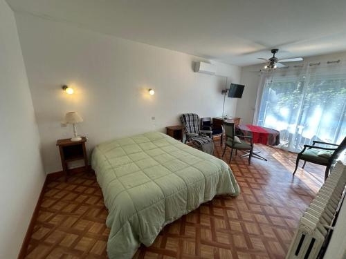 a bedroom with a bed and a living room at Résidence Les Milandes in Cazaubon
