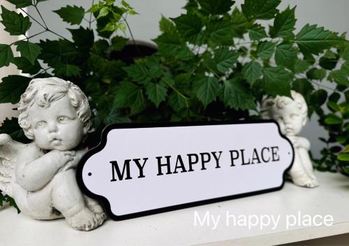 a little angel statue sitting next to a happy place sign at My Happy Place in Nonthaburi
