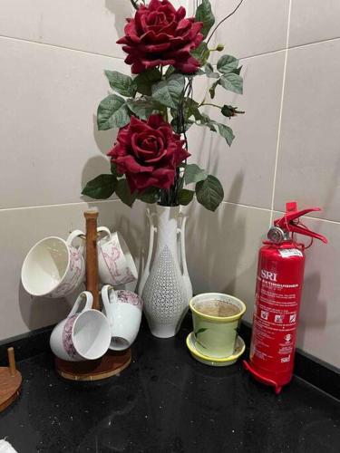 a table with a vase with red roses in it at Bungalow in exclusive area in Nibung Tebal