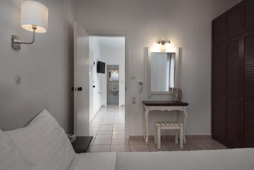 a bedroom with a bed and a table and a mirror at Diamond Apartments & Suites in Hersonissos