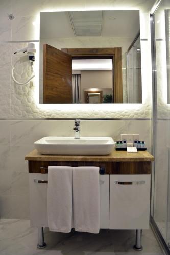 a bathroom with a sink and a mirror at Görükle Güler Park Hotel in Gorukle