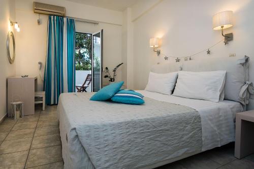 a bedroom with a bed with blue pillows on it at Diamond Apartments & Suites in Hersonissos