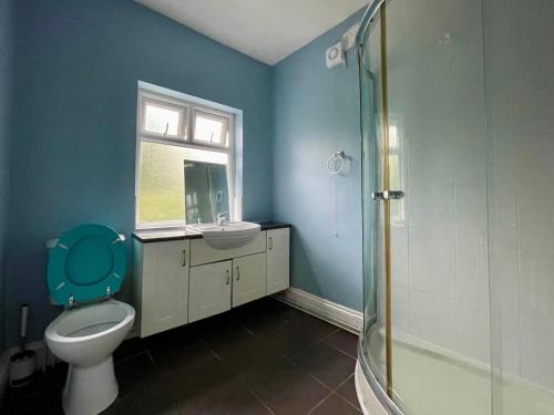 a bathroom with a toilet and a sink and a shower at Stylish 3-Bedroom Home! in Bedworth