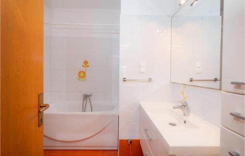 a white bathroom with a tub and a sink at 5 Bedroom Lovely Home In Posedarje in Posedarje