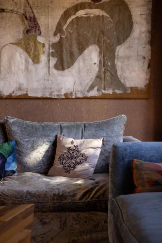 a couch with a pillow and a picture on the wall at Jnane Allia in Douar Soukkane